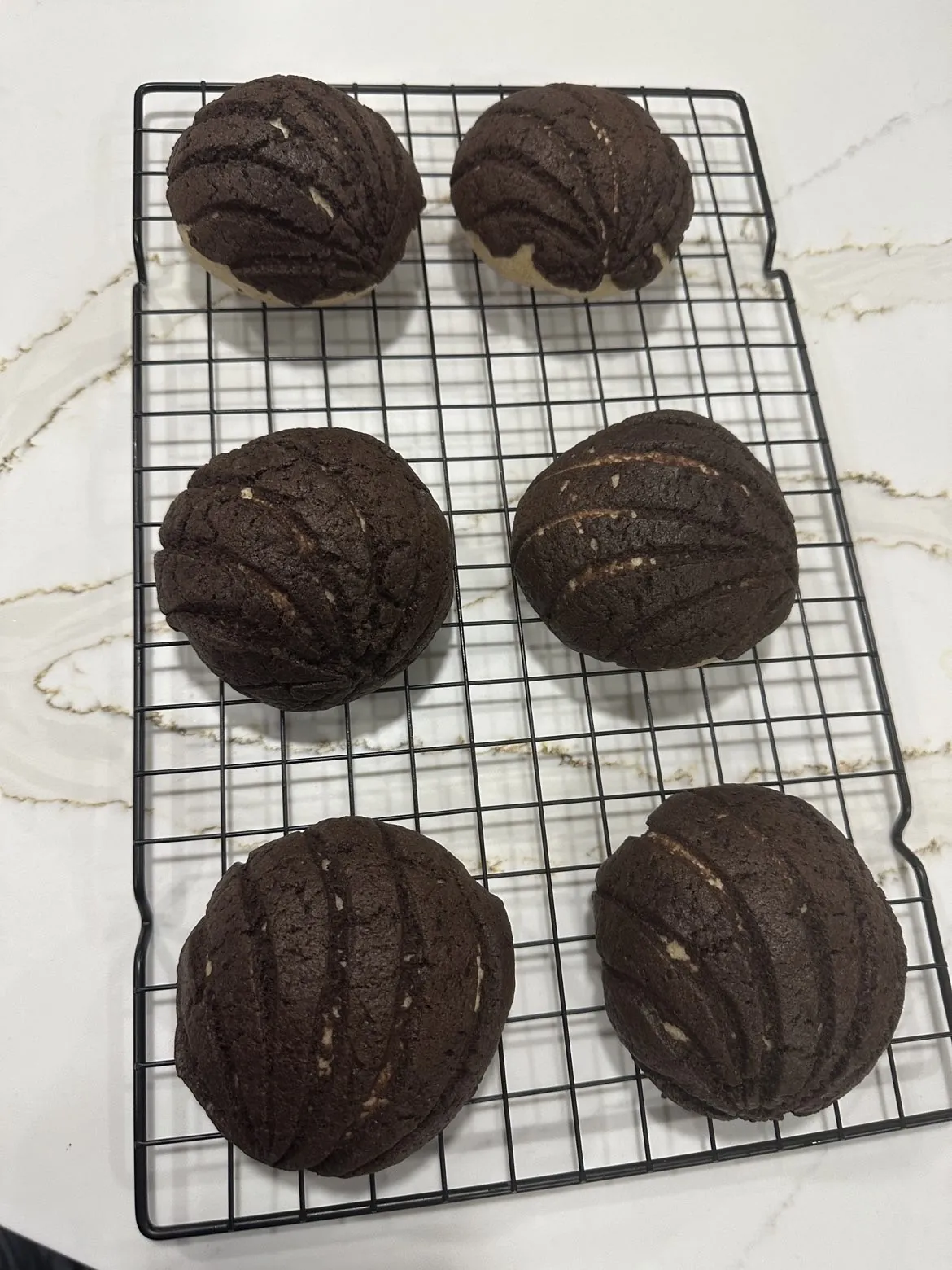 Chocolate conchas cooling on a wire rack at Kassey's Kitchen
